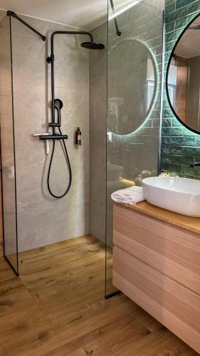 a bathroom with a glass shower and a sink at Apartamenty Drewno i Kamień in Wetlina