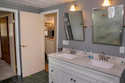 a bathroom with two sinks and a mirror at Green Acre on Lamoka Lake in Hammondsport
