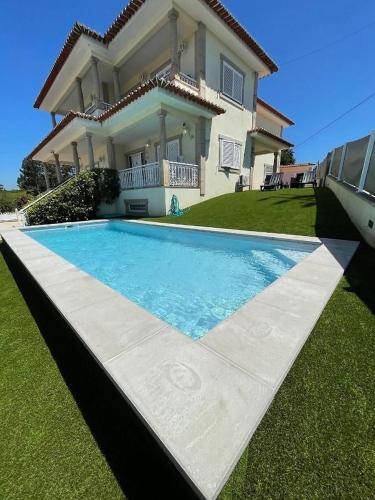 a house with a swimming pool in front of a house at Lux House in Ferreira
