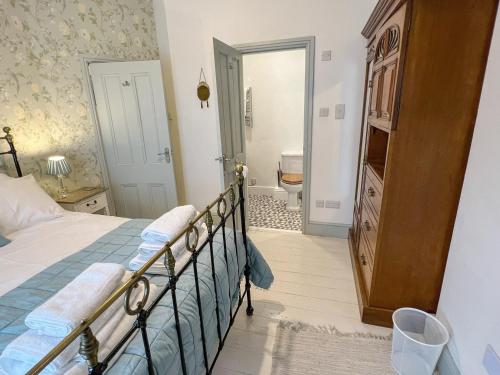 a bedroom with a bed and a bathroom at Llys Deulyn in Trefriw