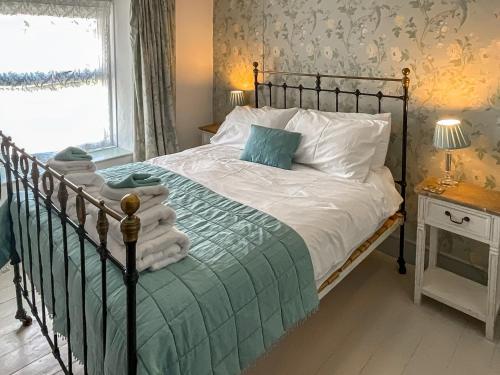a bedroom with a bed with green and white sheets at Llys Deulyn in Trefriw