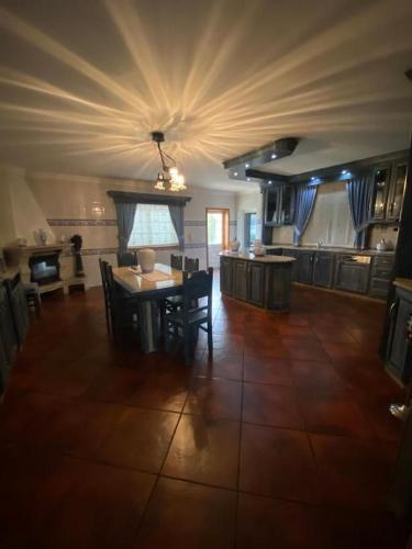 a living room with a table and a kitchen at Lux House in Ferreira