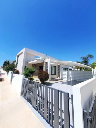 a house with a white fence in front of it at Panorama Luxury Summer Villa in Protaras