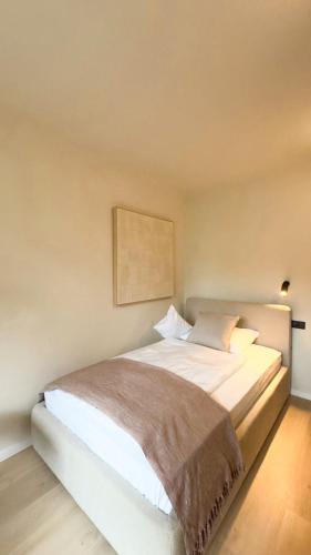 a bedroom with a white bed with a brown blanket at Hotel Weinhaus Kreuter in Koblenz
