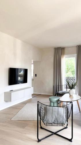 a living room with a tv and a table at Hotel Weinhaus Kreuter in Koblenz