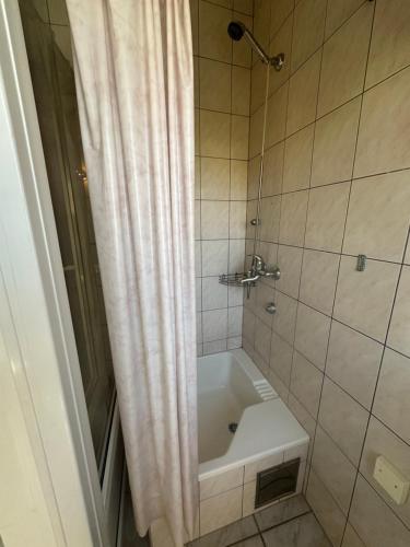 a bathroom with a tub and a shower with a shower curtain at Apartments Renato in Vrboska