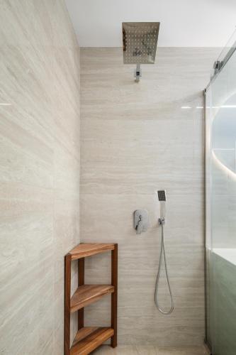 a bathroom with a shower and a wooden shelf at Medusa Accommodation in Livadakia