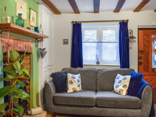 ein Wohnzimmer mit einer Couch und einem Fenster in der Unterkunft Well Cottage in Welton