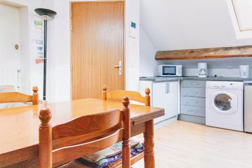une cuisine avec une table en bois et un lave-linge/sèche-linge dans l'établissement Cosy apartment for 4, à Saint-Ouen