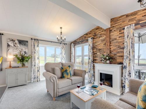 Una sala de estar con una silla y una chimenea. en Church View - Uk46896, en Kinlet