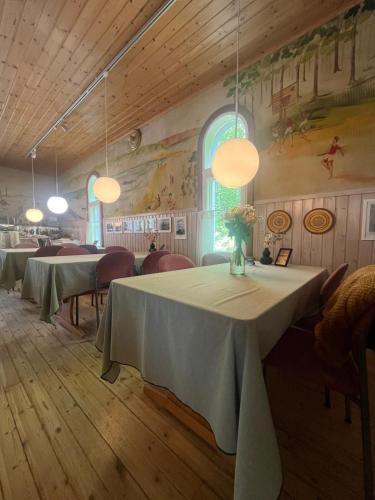 a dining room with tables and chairs and lights at Hostel Ukonlinna in Imatra