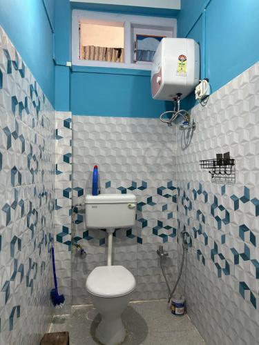 a bathroom with a toilet and blue and white tiles at Kunkhyab Homestay in Dirang Dzong