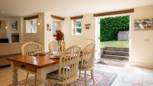une salle à manger avec une table et des chaises en bois dans l'établissement Pickett Cottage, à Hampnett