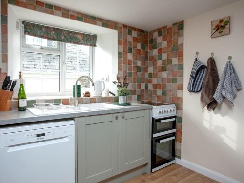 a kitchen with a sink and a stove at Garden Cottage in Kingsbridge