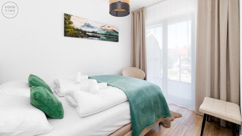 a bedroom with a bed with a green blanket on it at Apartamenty Good Time - Belle View - Centrum in Szklarska Poręba