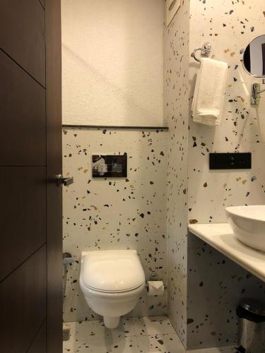 a bathroom with a toilet and a sink at Romeo Lane Mussoorie - The Courtyard House in Mussoorie