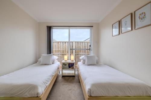 two beds in a room with a window at Albany Bayside by the BnB Collection in Albany