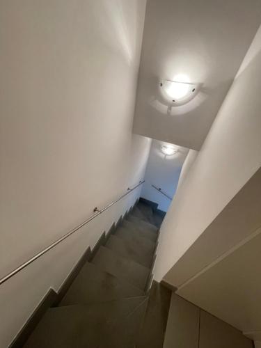 a staircase with a white wall and a light at Ara-Home in Aranova