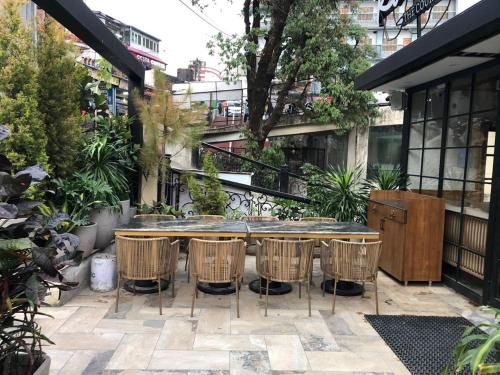 a patio with a table and some chairs at Romeo Lane Mussoorie - The Courtyard House in Mussoorie