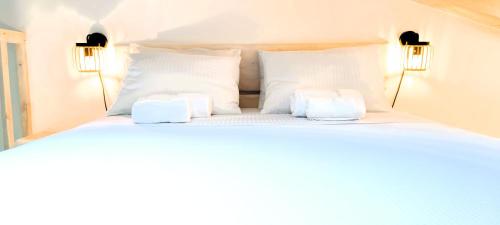 a white bed with two lamps on top of it at Chrisanthi's Cottage in Mougkelátika