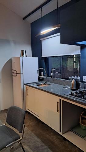 a kitchen with a refrigerator and a chair in it at Refúgio na Serra com Pôr do Sol in Feliz