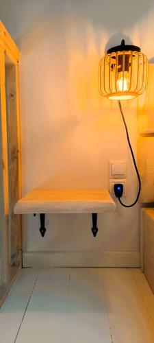 a light on a wall with a bench in a room at Chrisanthi's Cottage in Mougkelátika