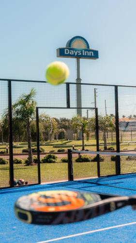 a yellow frisbee flying through the air next to a tennis court at Days Inn Zarate in Zárate