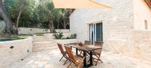 a wooden table and chairs on a patio at Chrisanthi's Cottage in Mougkelátika
