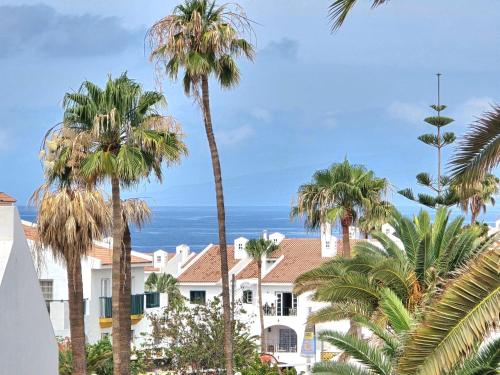a view of a building with palm trees and the ocean at Apartment Orlando Sea in Adeje