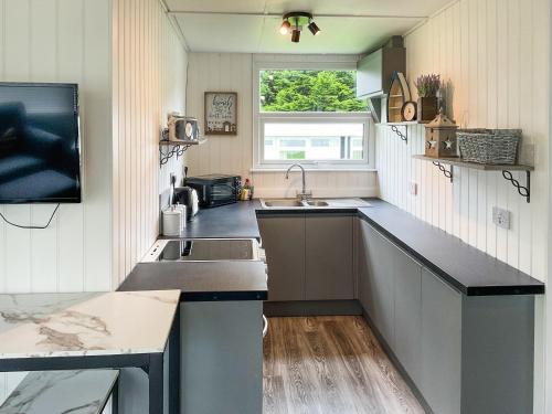 eine Küche mit Spüle und Arbeitsplatte in der Unterkunft Pebbles - Uk48098 in Haverfordwest