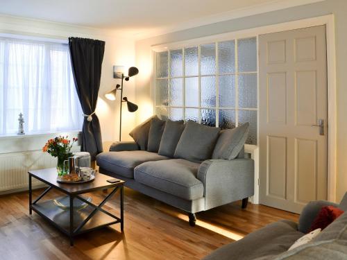 a living room with a couch and a table at April Cottage in Sewerby