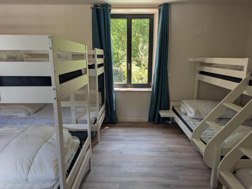 une chambre avec trois lits superposés et une fenêtre dans l'établissement Gîte de la Fède, à Fondamente
