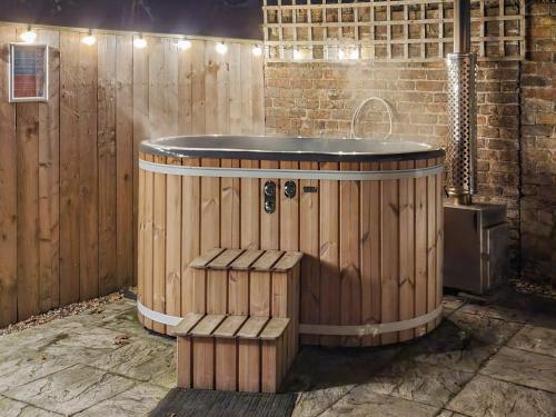 a wooden tub in a bathroom with a wooden fence at West End Lodge in Barmston