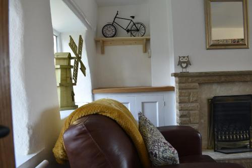 a living room with a couch and a bike on the wall at Windmill Cottage in Little Eaton