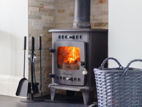 a stove in a room with a basket next to it at Court House in Porthcawl