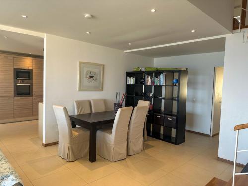 a dining room with a black table and white chairs at Aegean Blue Seafront Apartment in Sissi
