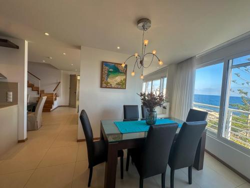 a dining room with a table and chairs and the ocean at Aegean Blue Seafront Apartment in Sissi