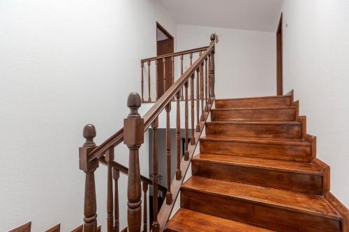 a wooden staircase with wooden railings in a house at Casa José & Maria, casa espaçosa para famílias e grupos até 10 pessoas in Braga