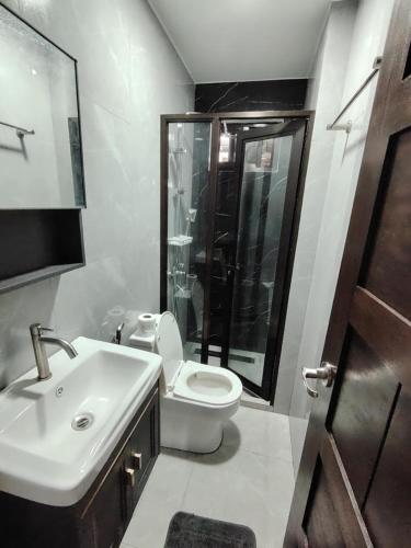 a bathroom with a toilet and a sink and a shower at CPH Modern House in Dirita
