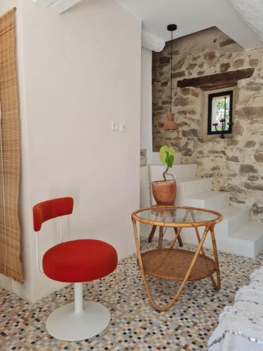 une chaise rouge et une table en verre dans une pièce dans l'établissement Gîte de charme entre terre & mer, à Landaul