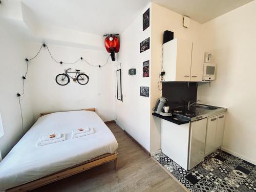 Cette petite chambre comprend un lit et une cuisine. dans l'établissement Lys 7 magnifique studio tout équipé proche de tout, à Reims