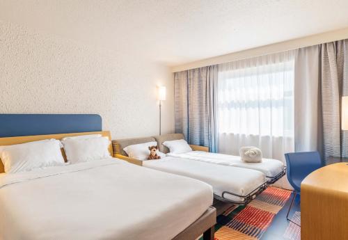 a hotel room with two beds and a window at B&B HOTEL Lyon Nord 4 étoiles in Dardilly