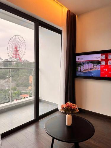 a room with a table and a large window and a ferris wheel at Căn hộ khách sạn Hạ Long Premier Sapphire in Ha Long