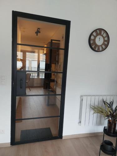 a mirror in a room with a clock on a wall at Modern and cozy apartment in Middelkerke