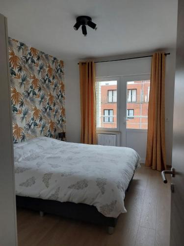 a bedroom with a bed and a window at Modern and cozy apartment in Middelkerke