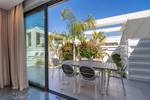 a table and chairs on the balcony of a house at Panorama Luxury Summer Villa in Protaras