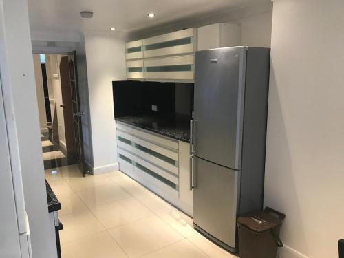 a kitchen with a stainless steel refrigerator at beautifull house with 6 double bedrooms in London