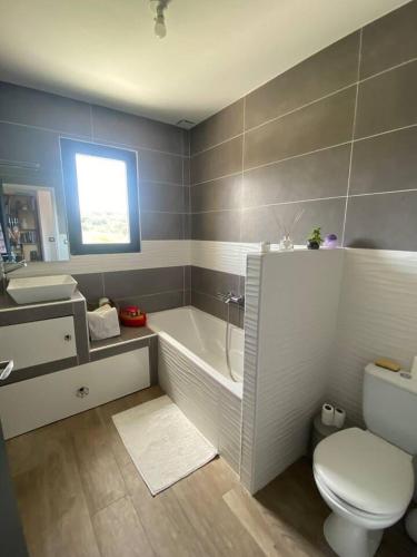 une salle de bain avec une baignoire, des toilettes et un lavabo dans l'établissement Villa piscine, 8personnes, clim, wifi, à Baixas