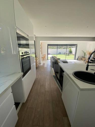 une cuisine avec des armoires blanches et un comptoir dans l'établissement Villa piscine, 8personnes, clim, wifi, à Baixas