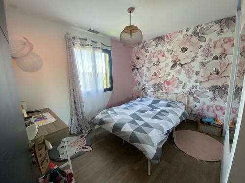 une chambre avec un lit avec un papier peint fleuri dans l'établissement Villa piscine, 8personnes, clim, wifi, à Baixas